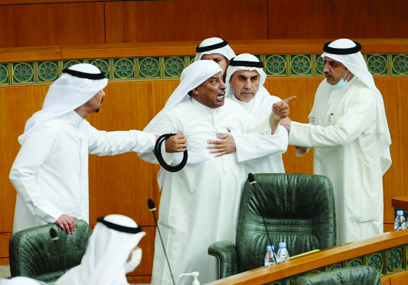 MP Salman Al-Azmi is restrained by other lawmakers during a scuffle. <br>