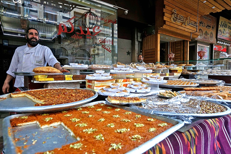 Syrian vendors sell traditional sweets.<br>
