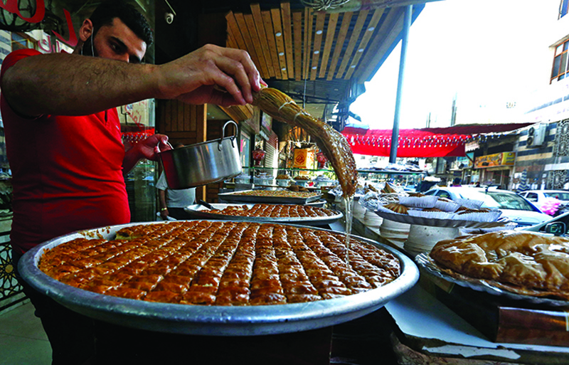 A Syrian vendor sells traditional sweets during the Muslim holy month of Ramadan.<br>