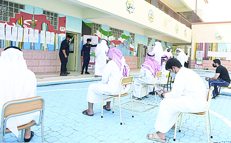 Voters wait for their turn to cast their votes at a polling station.<br>	<br>