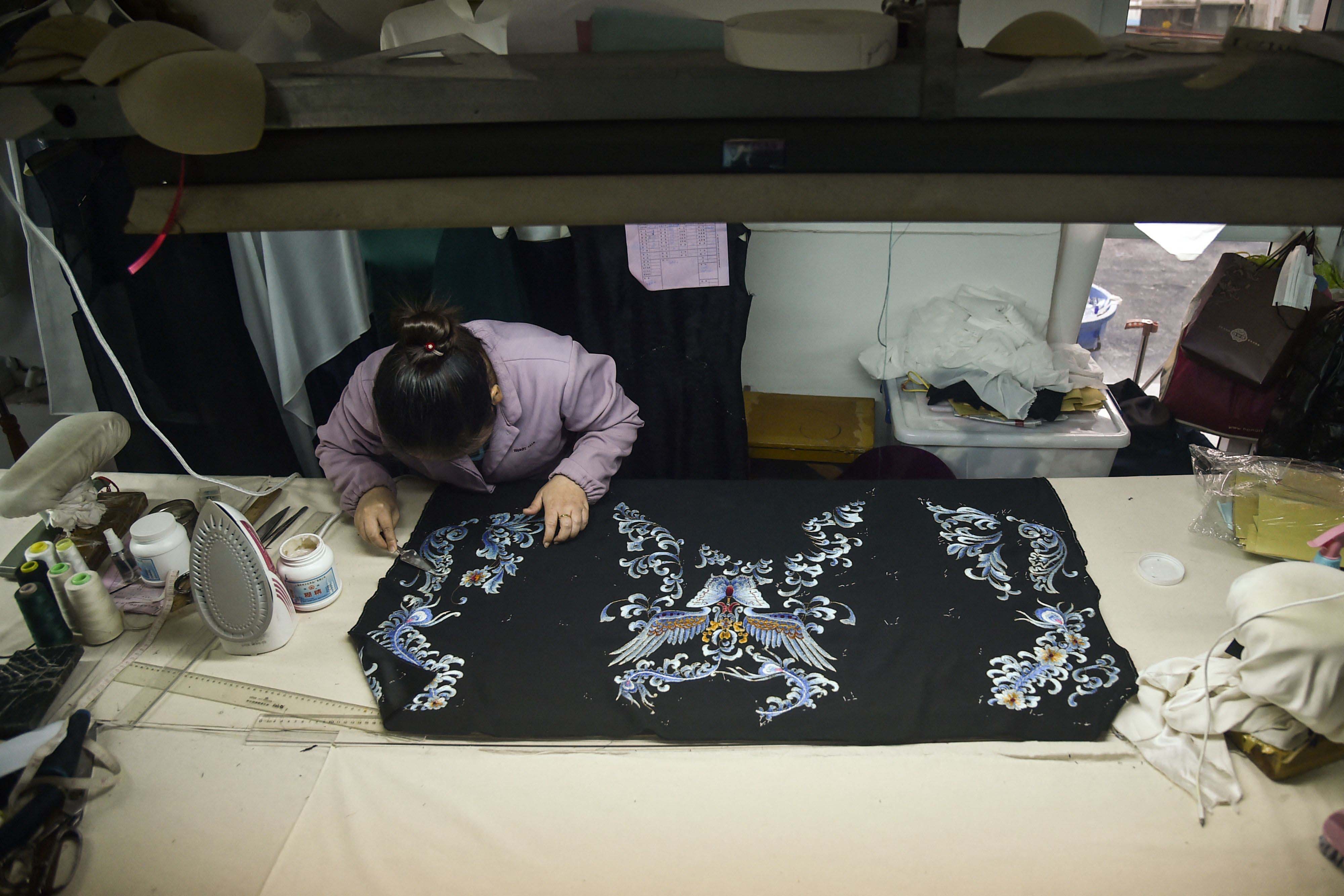 This photo shows a tailor making a traditional Chinese dress Qipao at a Qipao studio in Shanghai.<br>