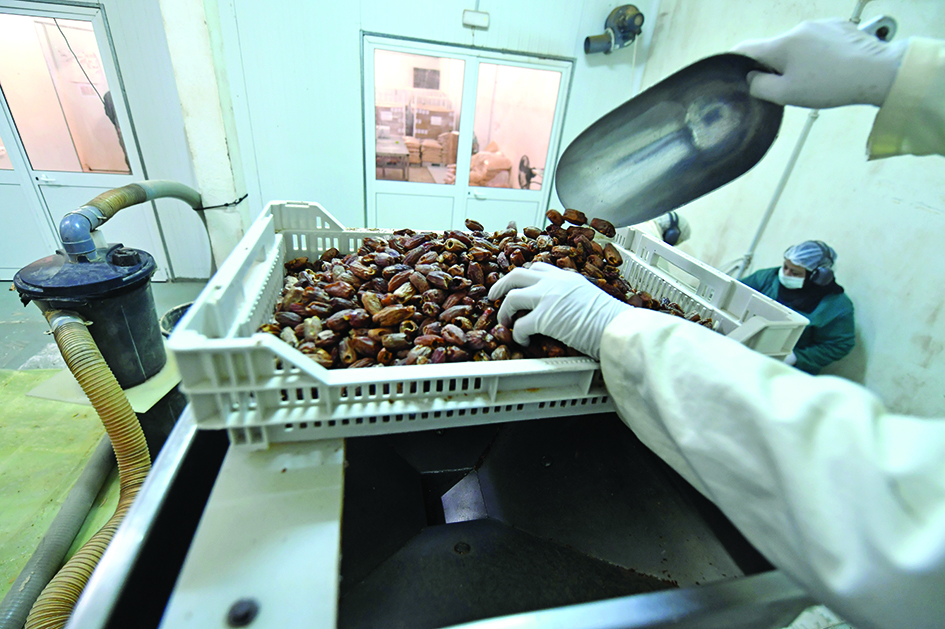 An employee grinds dates at Dateible, a company founded by US Kevin Klay selling “date sugar” produced from organic-certified desert fruits, in the remote Nefta oasis, a seven-hour drive from the coastal Tunisian capital Tunis.<br>