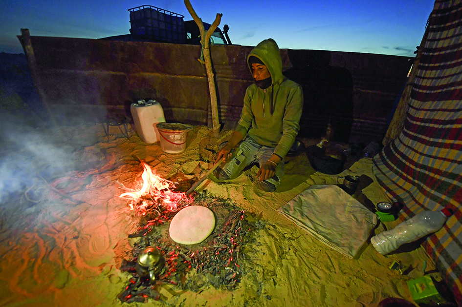 A camel herder prepares bread for his dinner in the Tunisian desert in Ong Jemel (Camel's Neck), near the Chott (salt lake) of Chtihatt Sghat, north of Tunisia's southwestern Nefta oasis. <br>