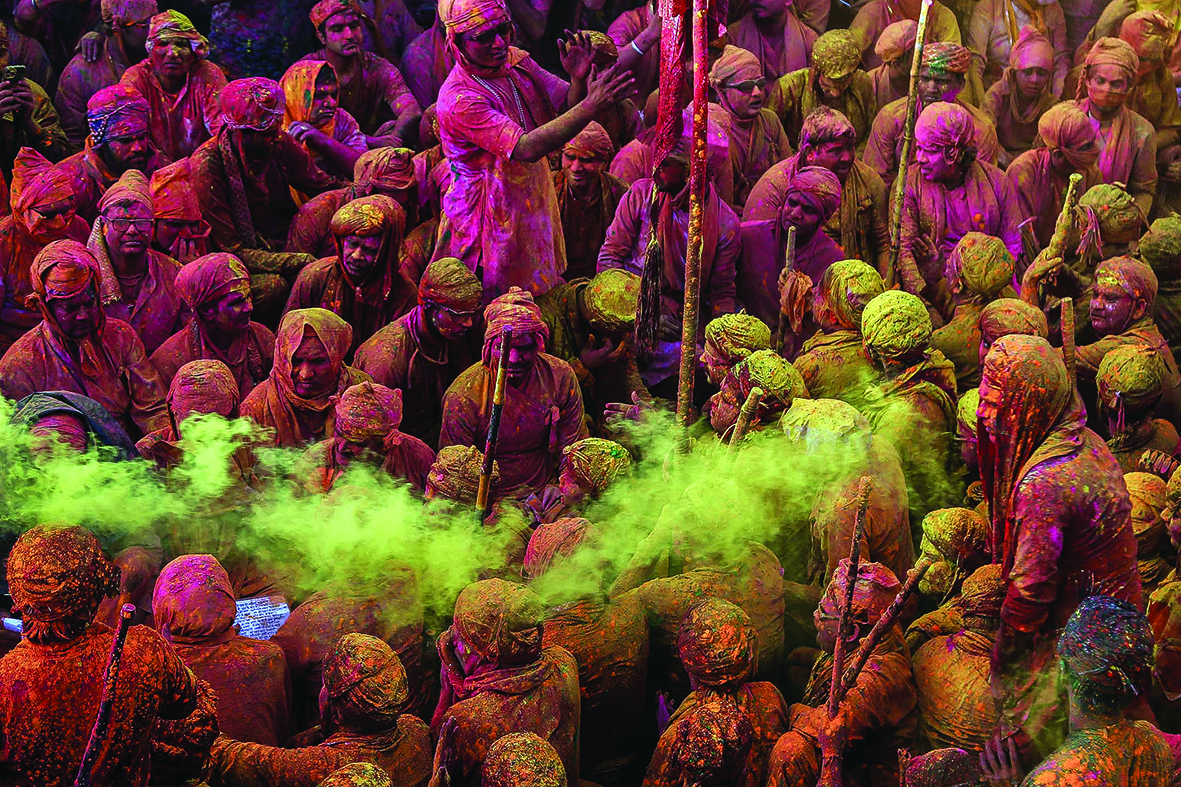 Revelers daubed in colors sing religious hymns during the Lathmar Holi celebrations.<br>