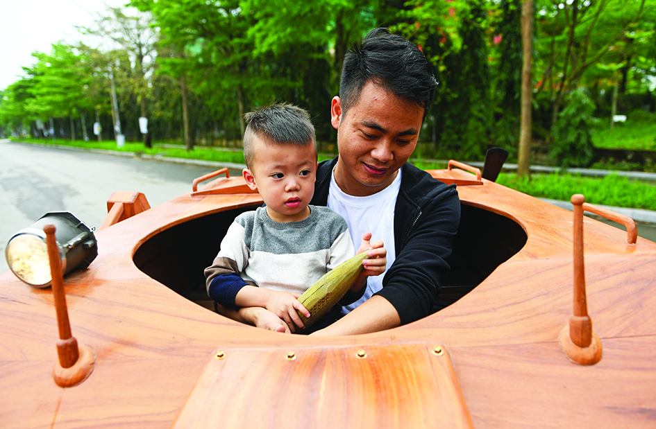 Truong Van Dao and his son ride in a wooden tank.