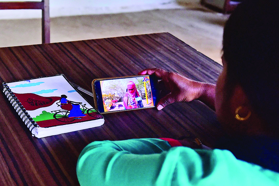 Meera Devi, managing editor and reporter of ‘Khabar Lahariya’ (Waves of News), watches a video on her phone in her office in Banda district, Uttar Pradesh state. <br>