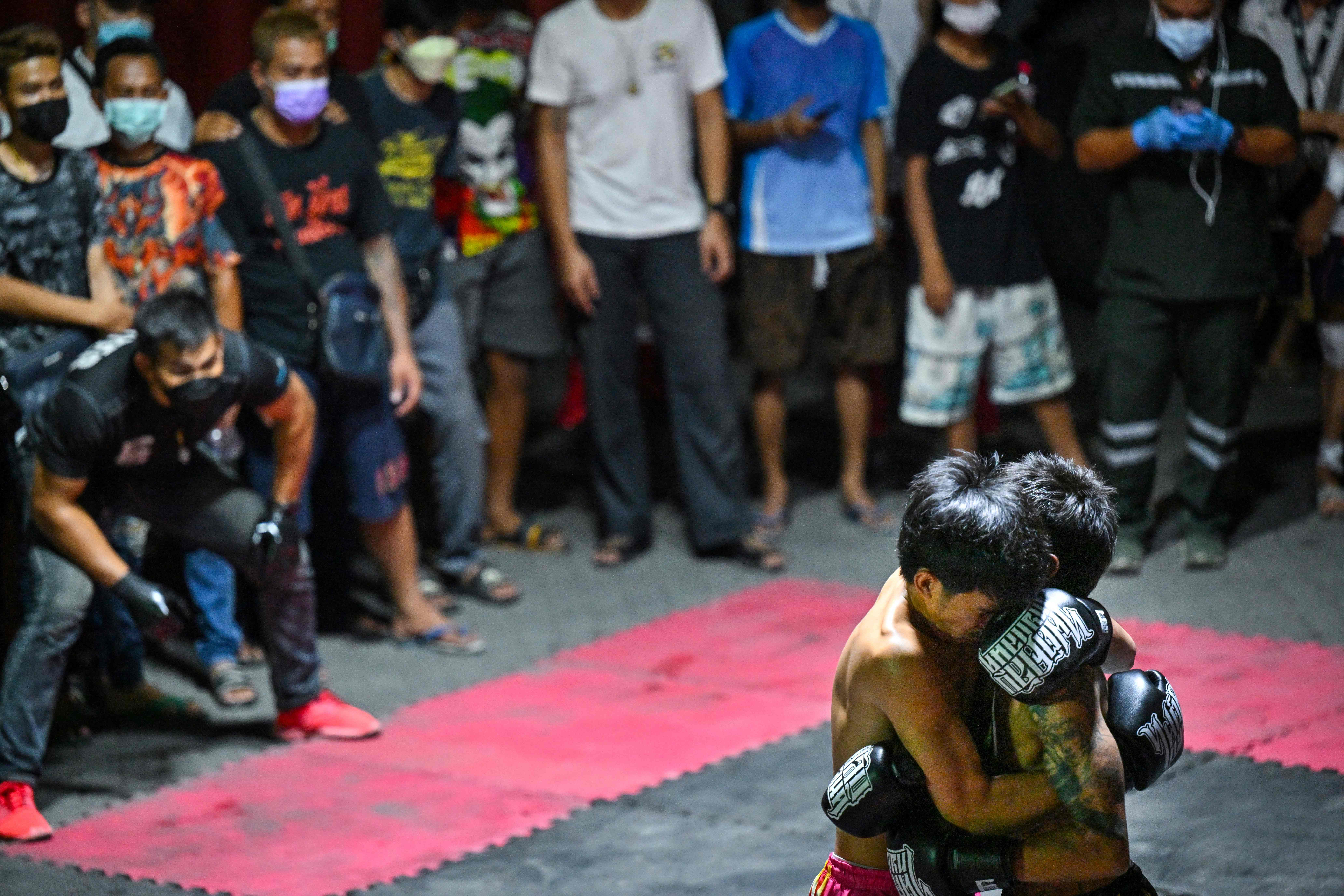 This photo shows combatants competing in Muay Thai at an event by Fight Club Thailand, an underground organization that hosts unsanctioned fights of various martial arts disciplines, in a parking lot in the Klong Toey district of Bangkok.