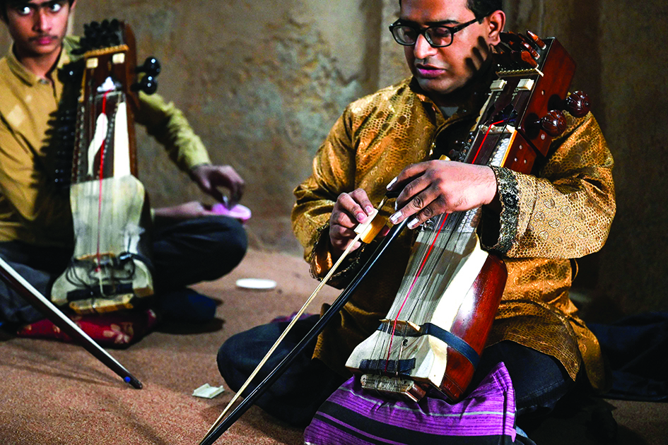 Zohaib Hassan (right) teaches his students to play sarangi at his academy in Lahore.