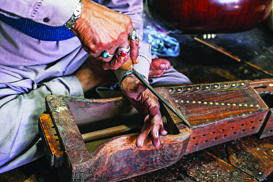 Ustad Zia-ud-Din repairs a traditional sarangi at his shop in Lahore.