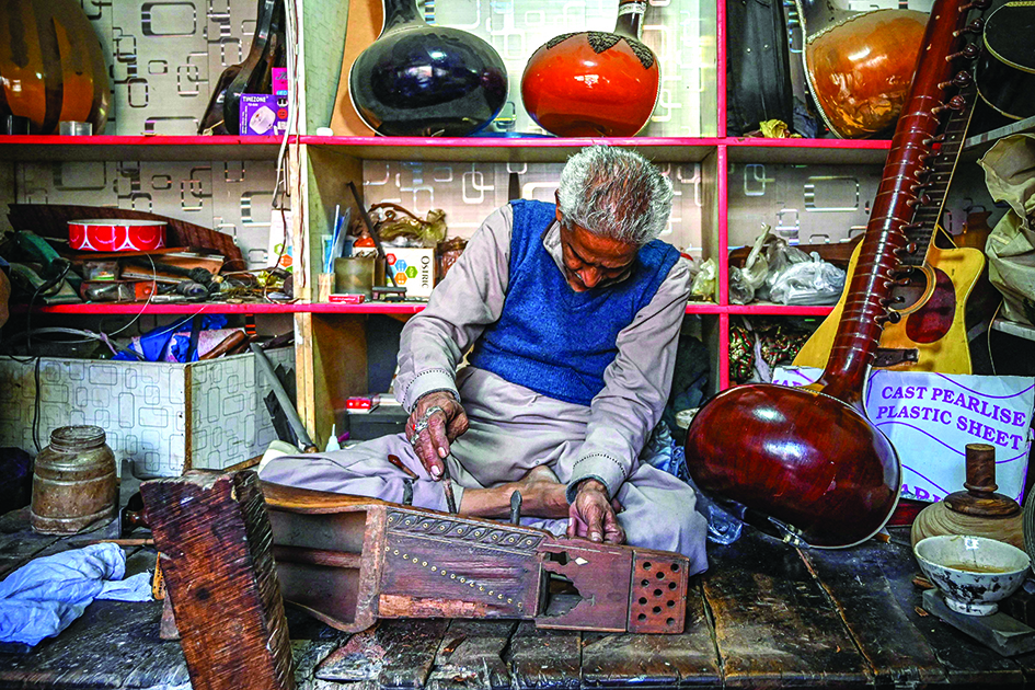 Ustad Zia-ud-Din repairs a traditional sarangi.