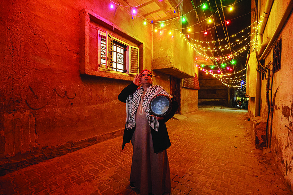 Fifty-year-old Palestinian Nizar Al-Dabbas, a “Musaharati” who plays the traditional role of “Ramadan drummer”, awakens Muslims for the pre-dawn traditional “suhur” meal before the start of the following day’s fast, during the holy month of Ramadan in Khan Yunis in the southern Gaza Strip.