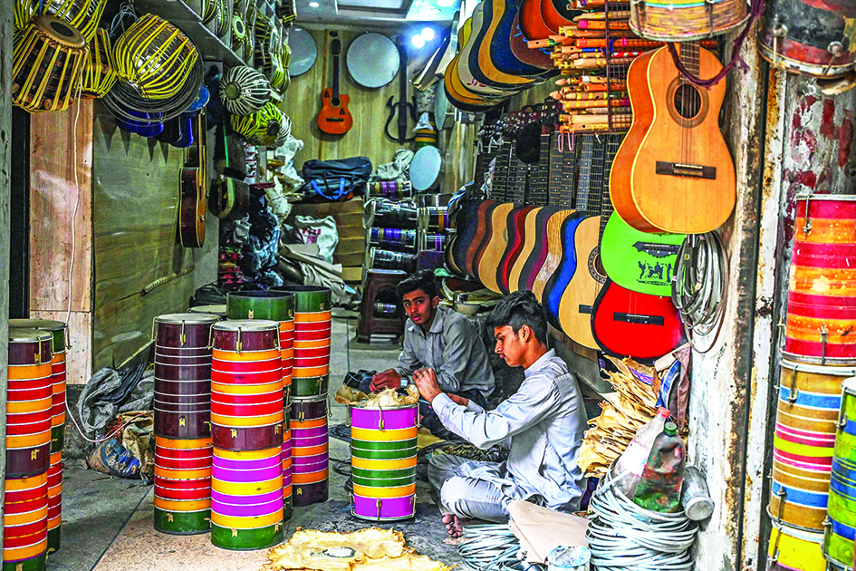  A shopkeeper (right) works at a musical instruments shop in Lahore.