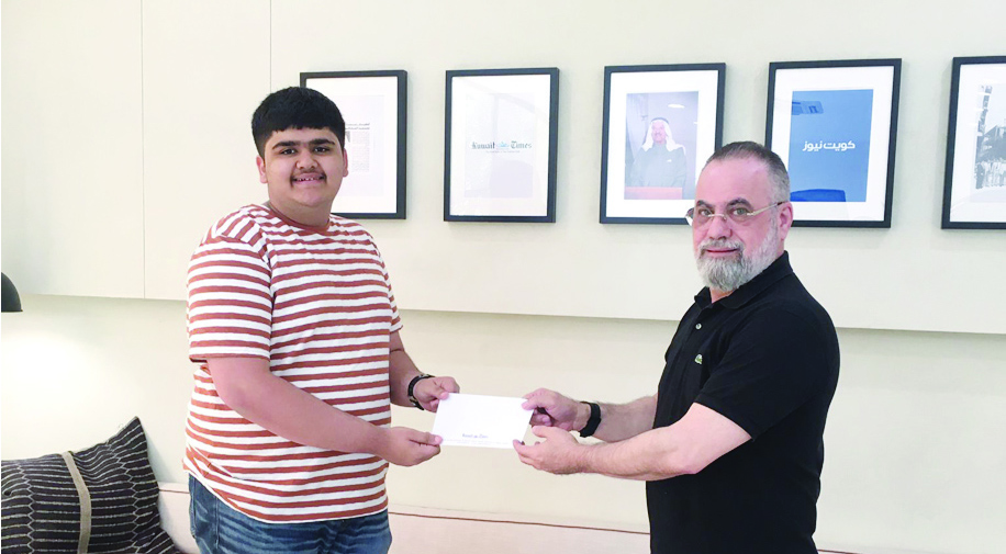 Pranav Ashok receives the award from Kuwait Times Advertising Manager Taleb Kanjo.