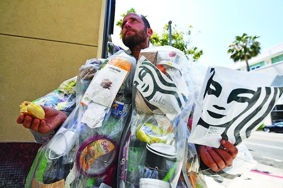 Environmental activist Rob Greenfield eats a breakfast sandwich while walking around Beverly Hills.