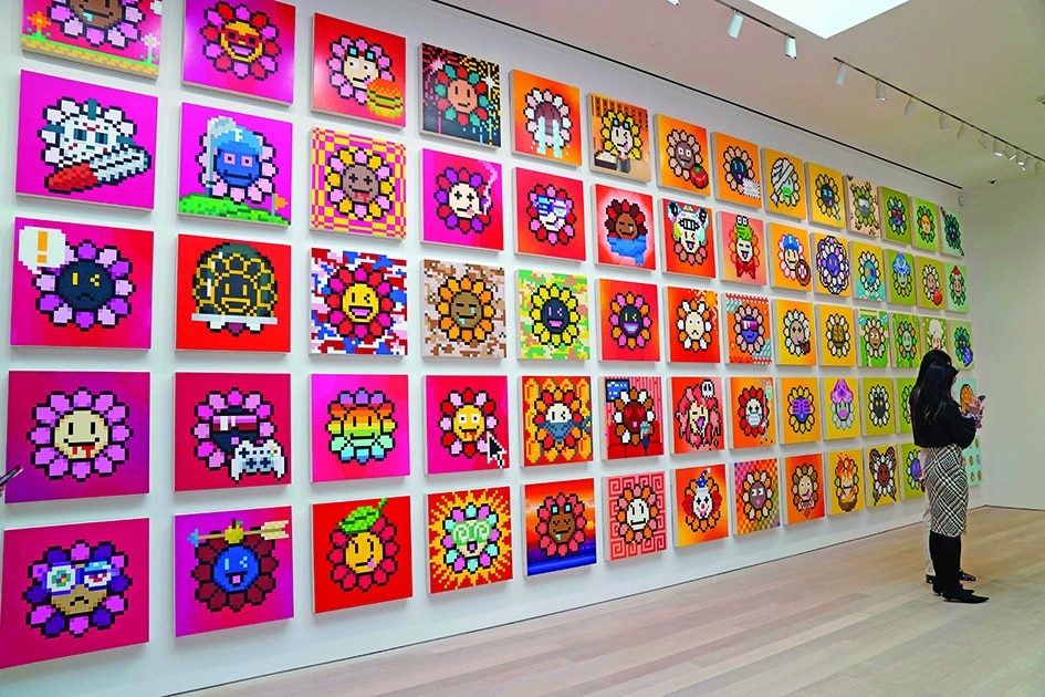 A person stands in front of artist Takashi Murakami's 'Flowers'. 