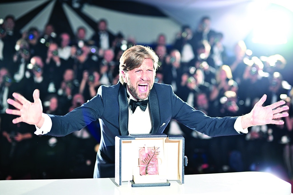 Swedish film director and screenwriter Ruben Ostlund poses with the trophy during a photocall after he won the Palme d'Or for the film 