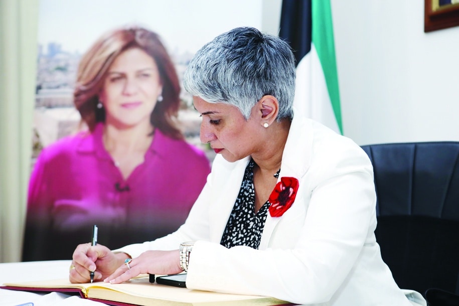 Canada's Ambassador to Kuwait Aliya Mawani writes in the condolences book.
