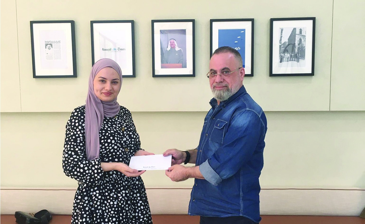 Aya Al-Tair receives the award from Kuwait Times Advertising Department Manager Taleb Kanjo.