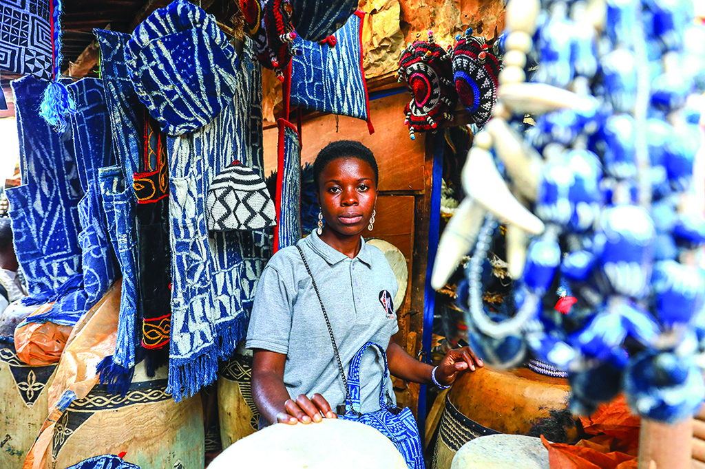 Yougo Teguia Doriane, 24, a designer and stylist, poses in a shop selling ndop clothes and accessories at Market B in Bafoussam.