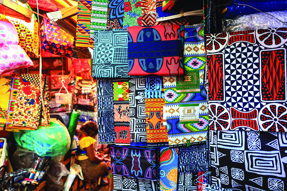 African fabrics, some styled in ndop fashion, hang in a Market B in Bafoussam.