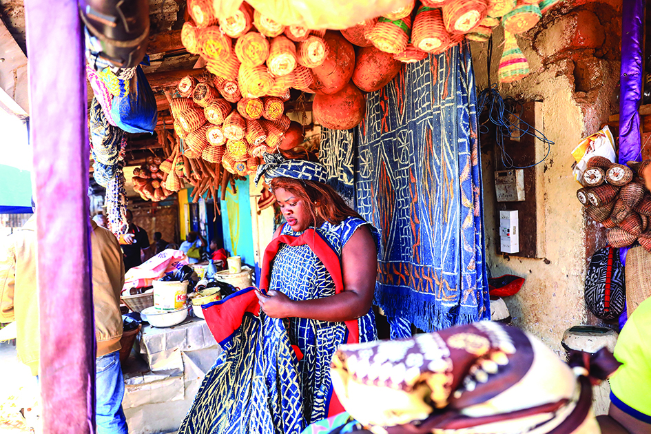 Kristelle, a trader of cultural products and accessories made from Ndop, sits at her shop in Batie.