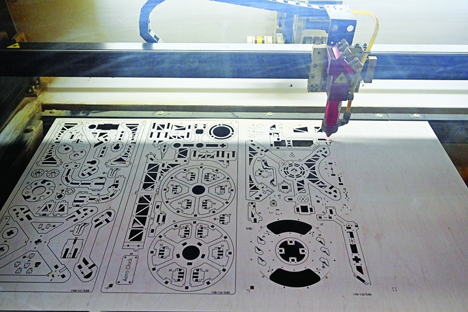 A picture shows a laser machine making parts of models in the workshop of wooden models manufacturing company Ugears.