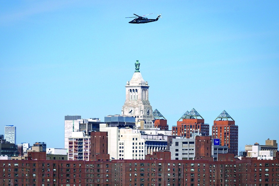 A helicopter flies above the city skyline of New York.