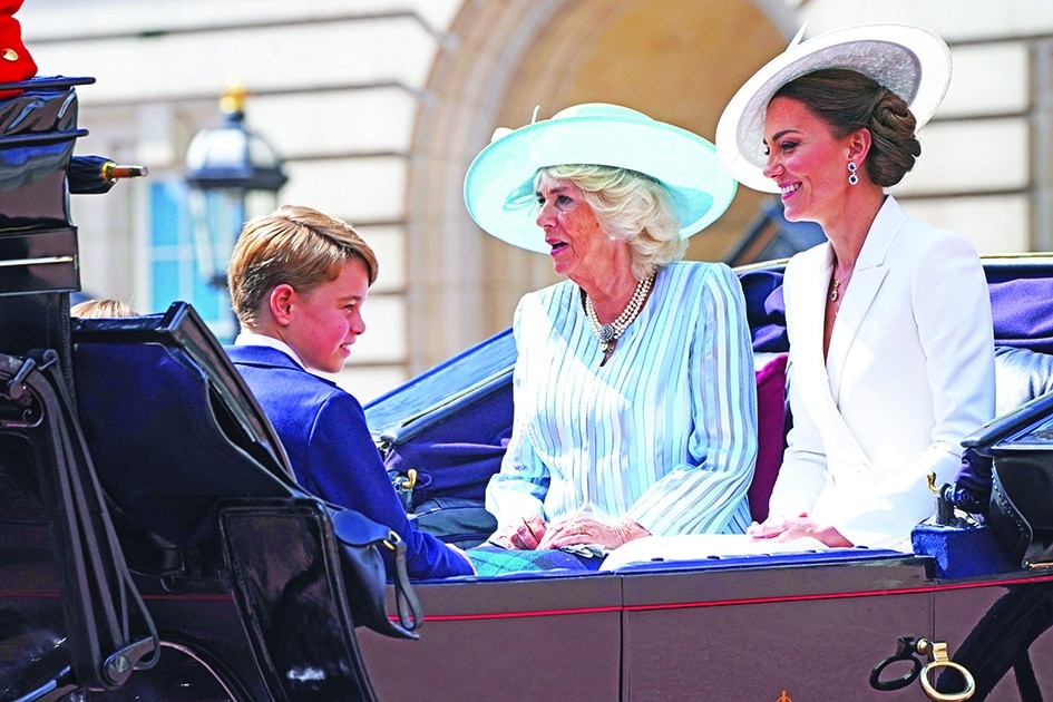 Britain's Prince George of Cambridge (left), Britain's Camilla, Duchess of Cornwall (center) and Britain's Catherine, Duchess of Cambridge (right) leave Buckingham Palace, on their way to the Queen's Birthday Parade.