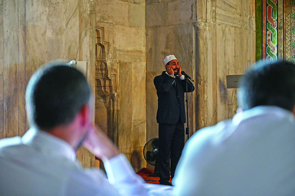 A Turkish muezzin performs the Ezan call to prayer in front of a jury, in Old mosque (Eski Camii) in Edirne.