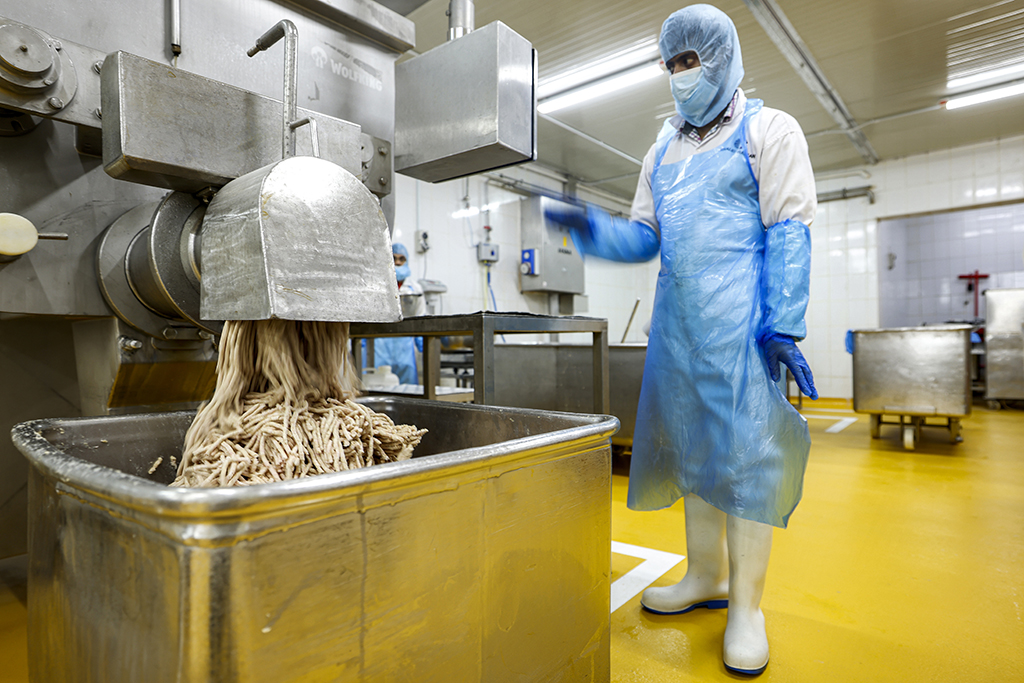 A mincer produces shreds of salicornia plant-based mix to be made into burger patties at a food processing plant.
