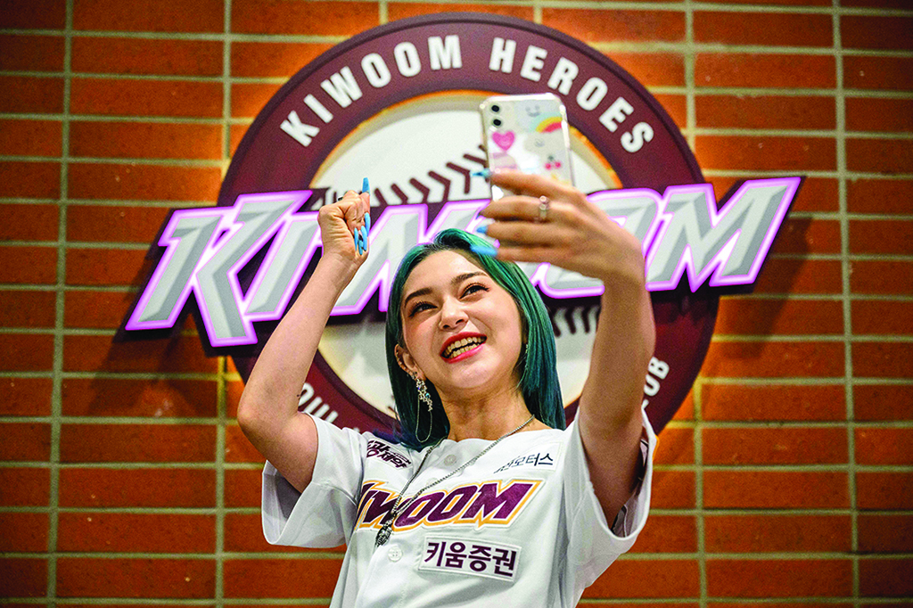 Korean-American K-pop star AleXa records a social media message for her fans before her performance and throwing of the first pitch before the start of a baseball match between South Korean teams Kiwoom Heroes and LG Twins at the Gocheok Sky Dome in Seoul.
