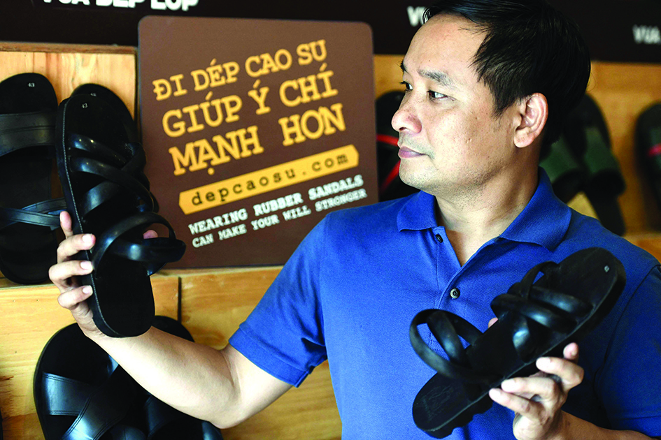 This photo shows Nguyen Tien Cuong posing with his company's rubber sandals at a showroom in Hanoi.