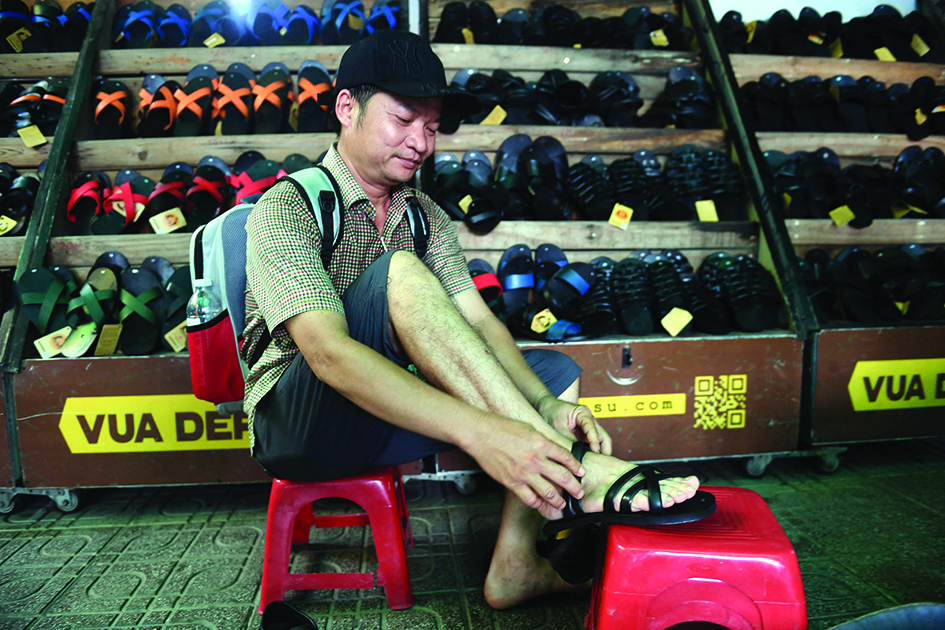 This photo shows a client trying on rubber sandals at a shop in Hanoi.