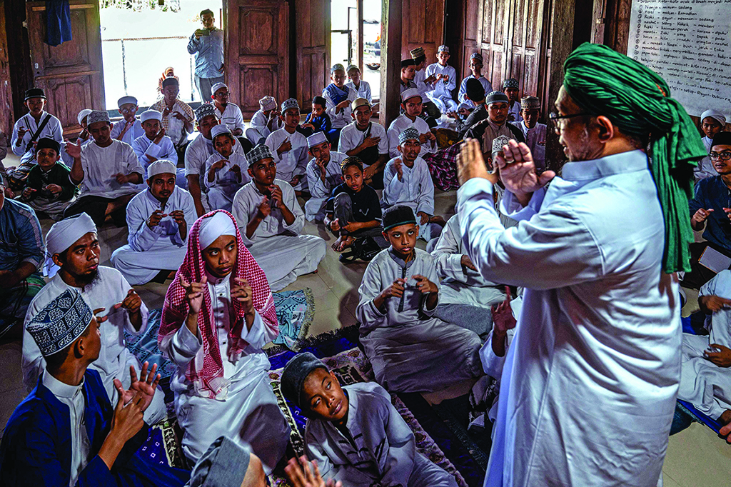 School founder Abu Kahfi (right) teaches students at an Islamic boarding school for deaf children in Sleman.