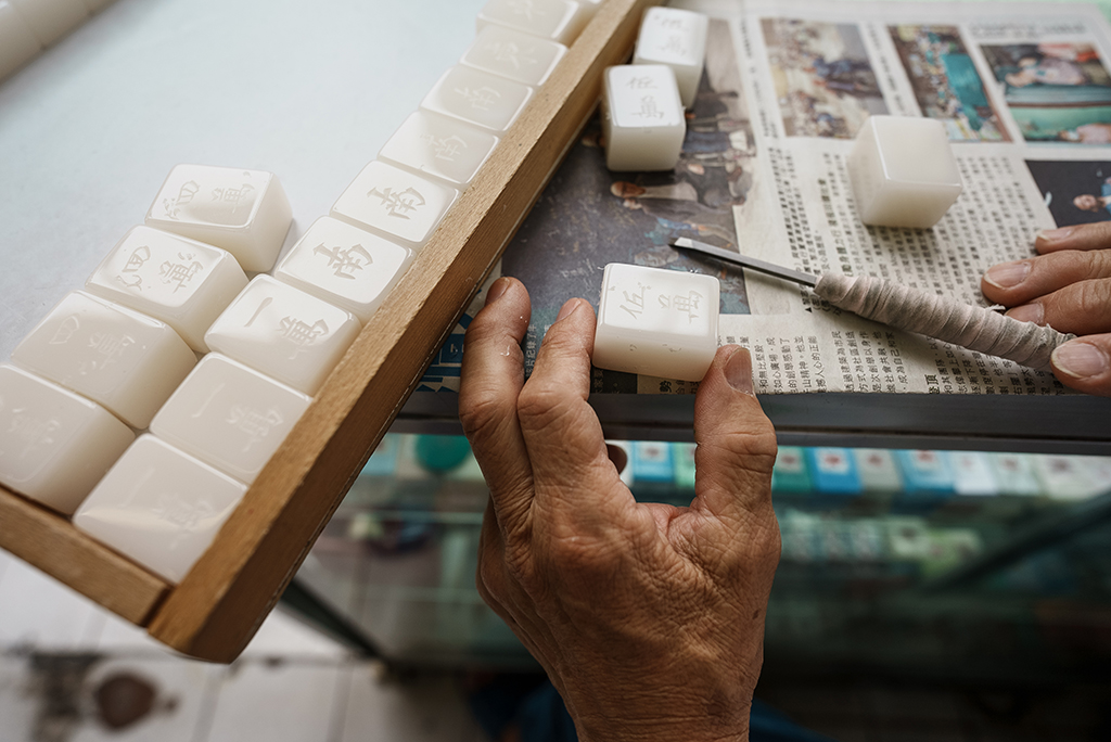 Mahjong tile artisan Cheung Shun-king, 70, preparing to paint mahjong pieces after carving characters on them.