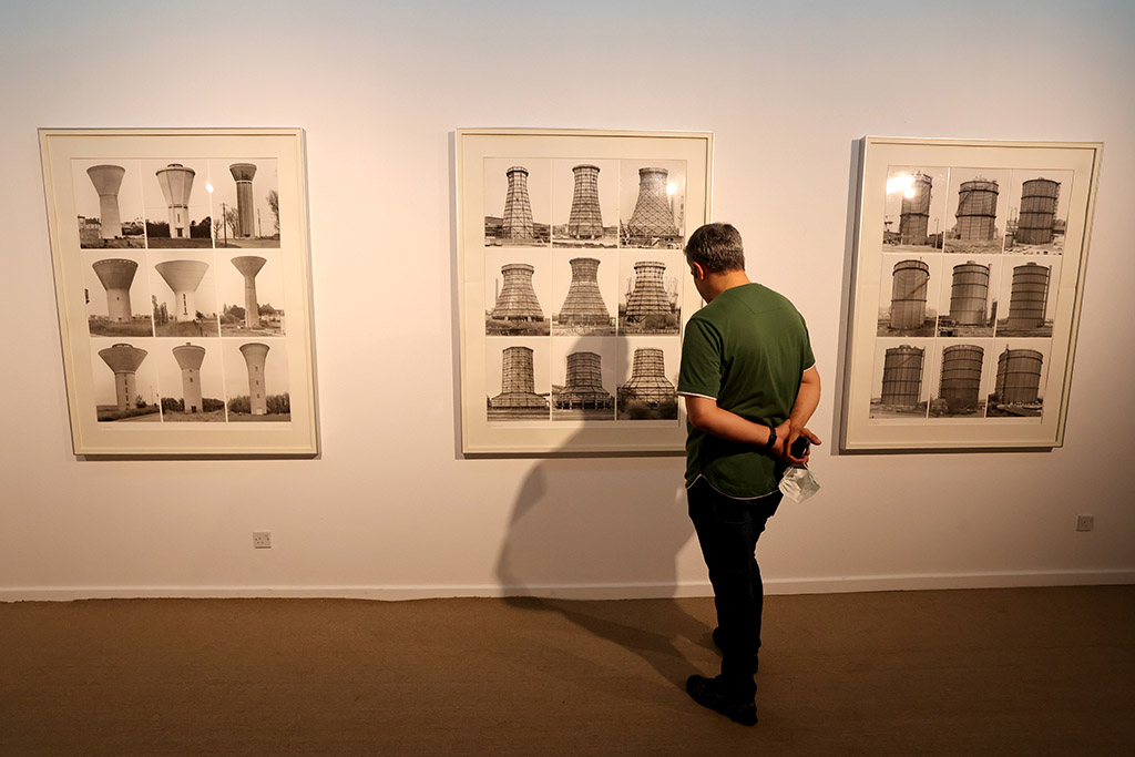 A visitor looks at artwork by German artists Bernd and Hilla Becher.