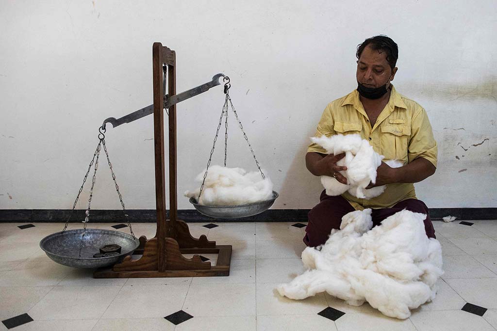 A worker weights cotton for the filling of a quilt at the workshop of Indian naturalized textile designer Brigitte Singh in Amber.