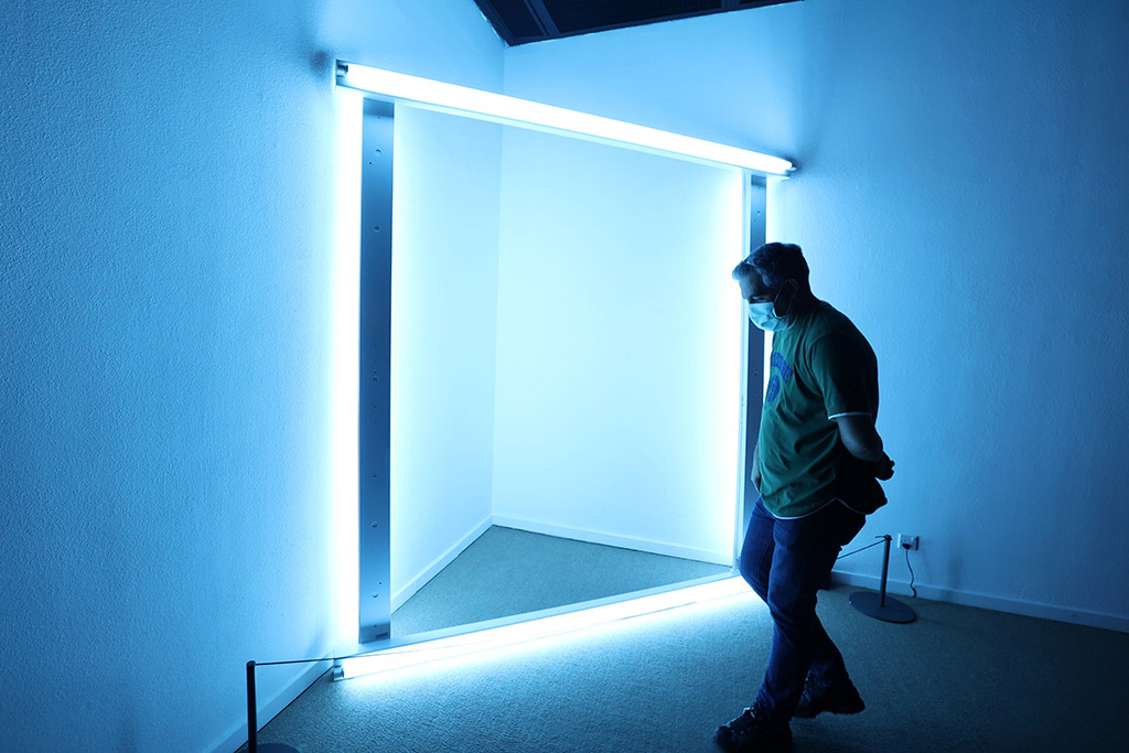 A visitor looks at an installation by American artist Dan Flavin.