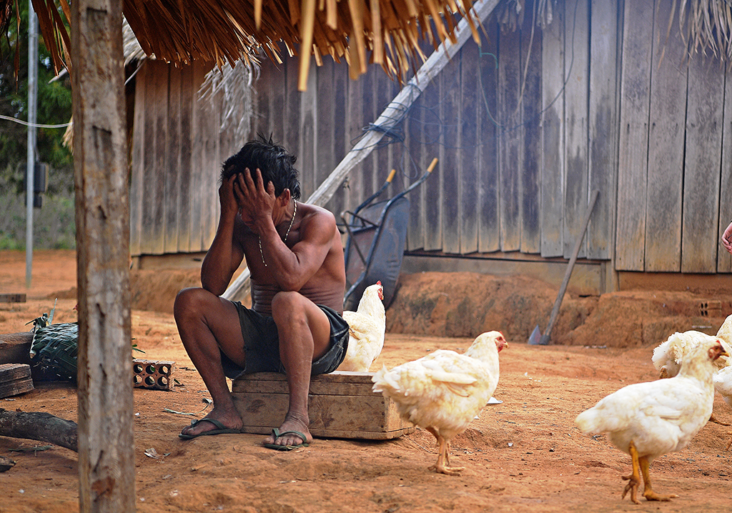 In this file photo a member of Uru Eu Wau Wau tribe covers his face in the tribe's reserve in the Amazon, south of Porto Velho, Brazil.