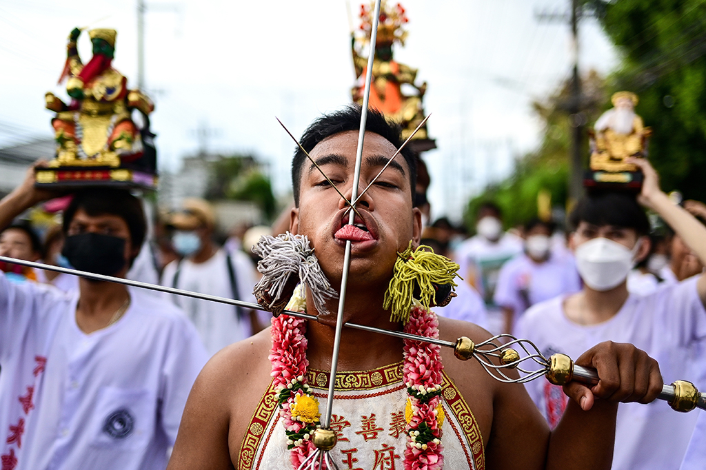 A devotee of the Jor Soo Gong Naka shrine with skewers pierced through the cheeks takes part in a procession during the annual Vegetarian Festival. 