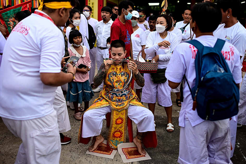 A devotee of the Jor Soo Gong Naka shrine with skewers pierced through the cheeks waits to take part in a procession during the annual Vegetarian Festival.