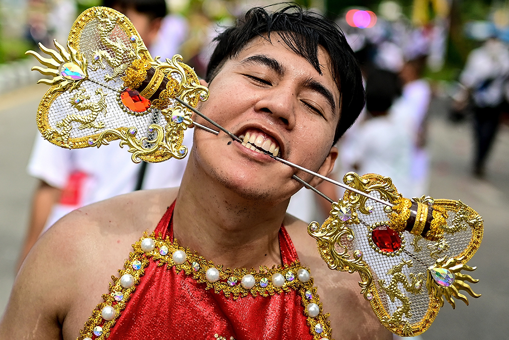 A devotee of the Jor Soo Gong Naka shrine with skewers pierced through the cheeks takes part in a procession.