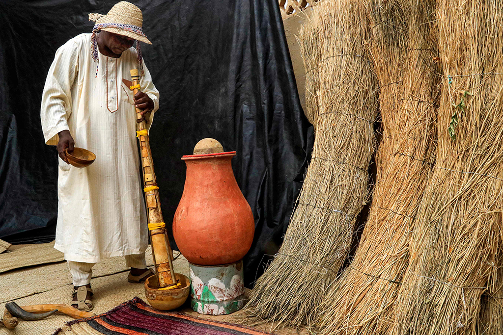 Dr Dafallah Al-Haj Ali Mustafa pours water down the pipe of the traditional 