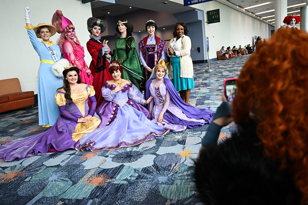 Fans take pictures as they cosplay in costumes as mothers from Disney films during the Walt Disney D23 Expo.