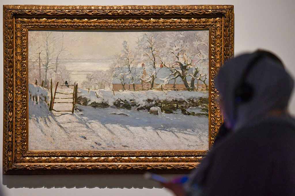A visitor looks at Claude Monet's masterpice The Magpie displayed at the exhibition 