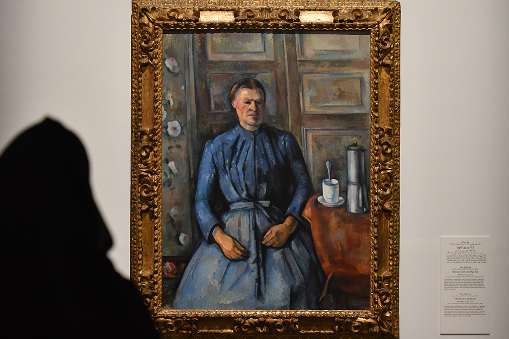 A visitor looks at Paul Cezanne's masterpiece Woman with a Coffee Pot displayed at the exhibition 
