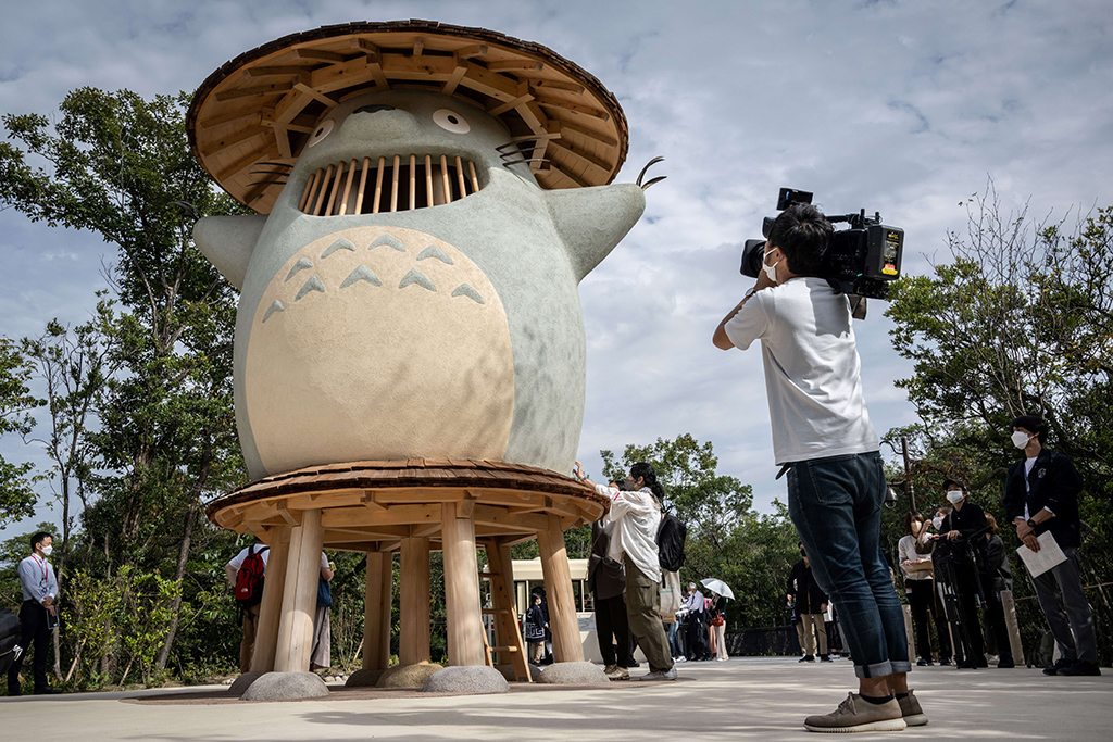 A member of the media takes video of an exhibit of Ghibli character 'Totoro' at Dondoko Forest during a media tour of the new Ghibli Park.