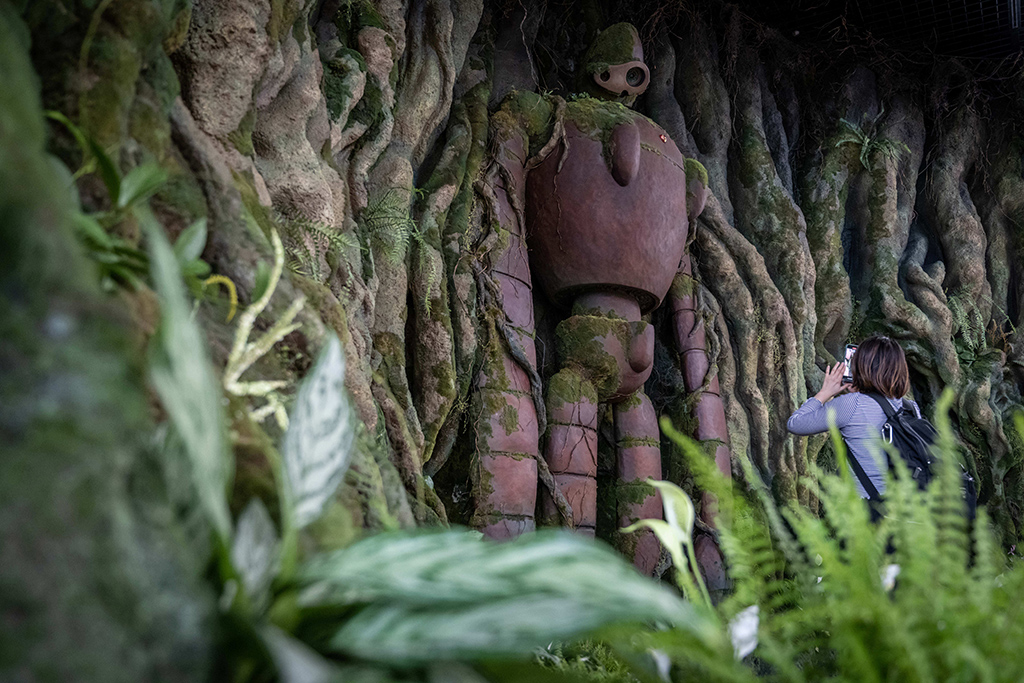 A member of the media takes a photograph of an exhibit at Ghibli's Grand Warehouse during a media tour of the new Ghibli Park.