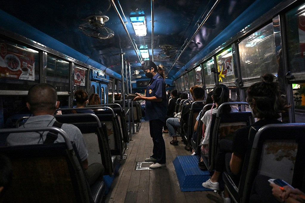 Conductor Arunee On-sawats collecting the fare from passengers on the No.8 bus in Bangkok.