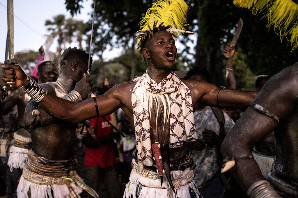 A young man, dressed in his traditional outfit, sings and dances during a ceremony marking the end of the yearly initiation process for young men in Kabrousse.